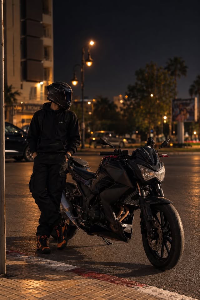Yasser Ajana in his helmet leaning on his motorcycle